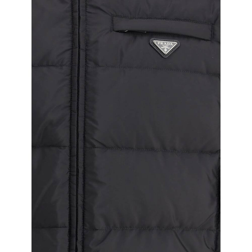 Re-nylon Down JacketPrada’s re-nylon Down Jacket combines sustainability and functionality with a modern design. It features a front zipper closure, two side pockets and a welt pocket on the chest. The distinctive triangular plaque sewn on the front and t