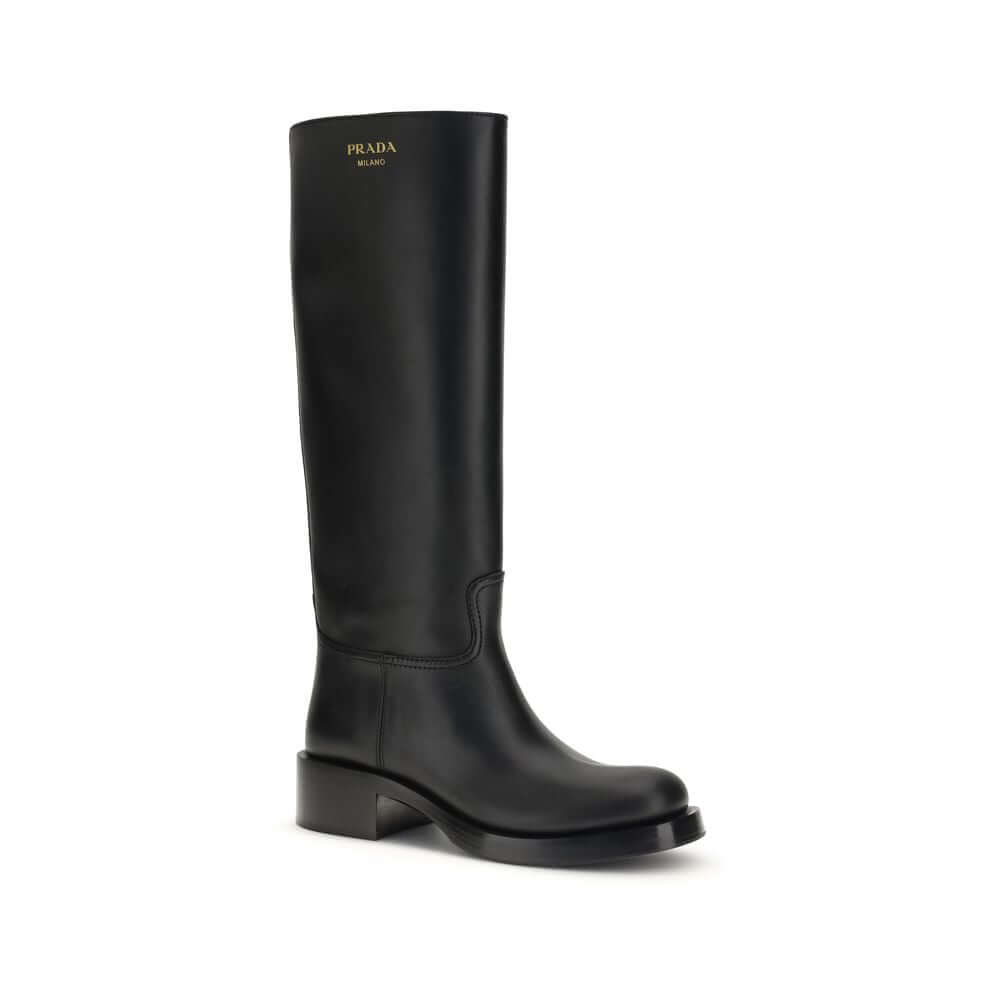 Black Calf Leather Bos Taurus BootsHigh Leather Boots by Prada are made of smooth leather and feature a sleek, essential design. They feature a round toe and are embellished with a laminated printed logo on the side, as well as a printed logo on the insid