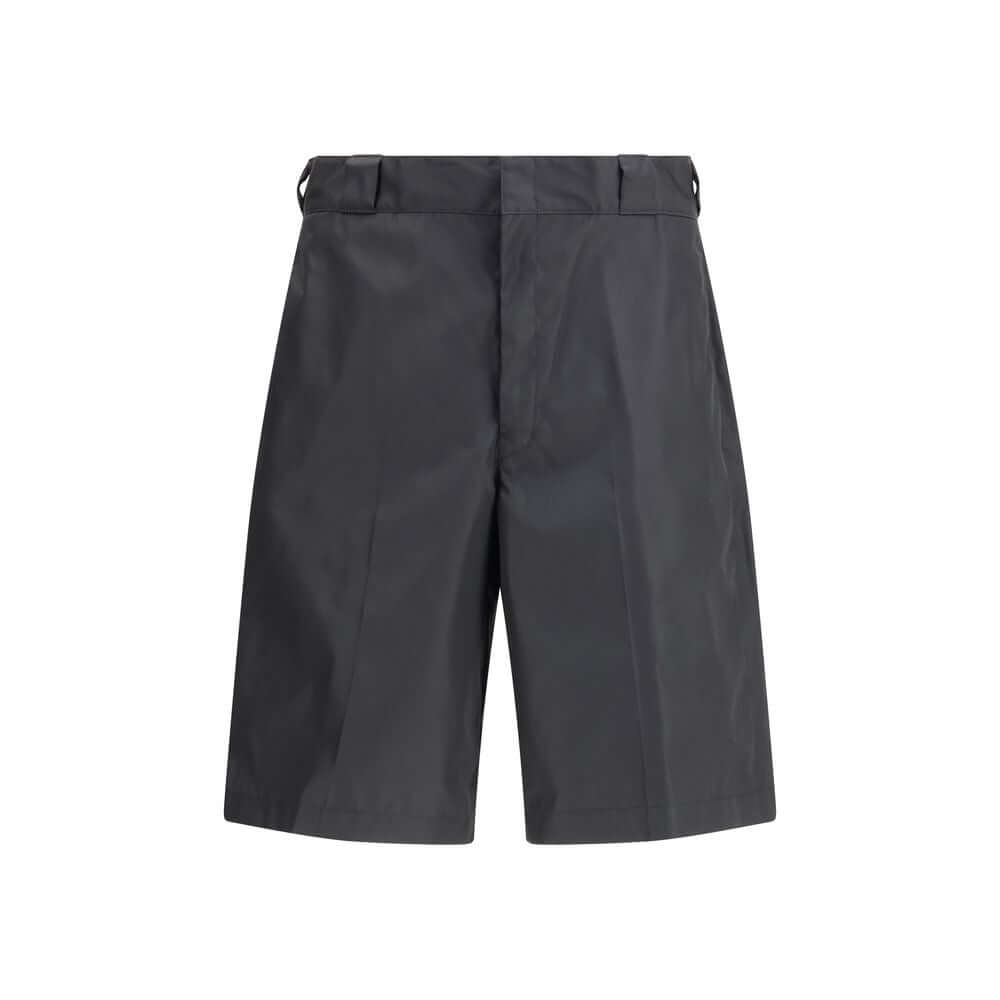 Black Recycled Polyamide Bermuda ShortsThe Re-Nylon Bermuda Shorts by Prada merge contemporary design with a sustainable ethos. Crafted from ECONYL®, a regenerated nylon yarn produced from recycled ocean plastics, fishing nets, and textile fibers, they em