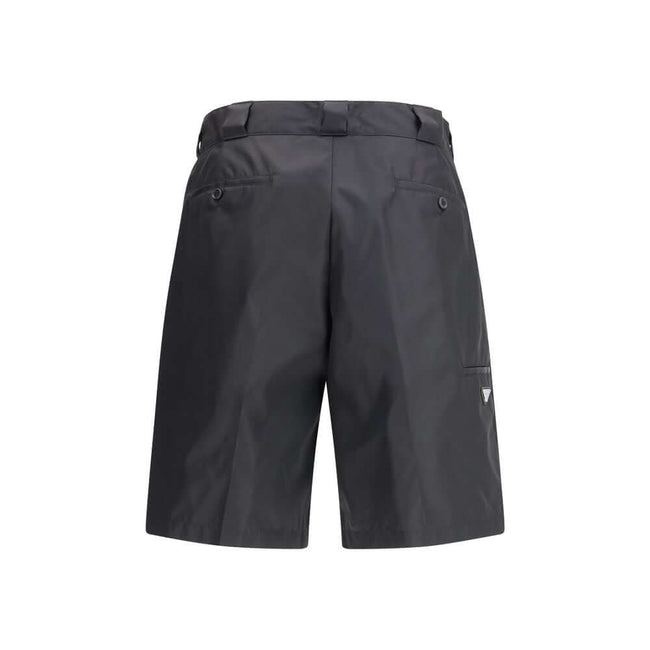 Black Recycled Polyamide Bermuda ShortsThe Re-Nylon Bermuda Shorts by Prada merge contemporary design with a sustainable ethos. Crafted from ECONYL®, a regenerated nylon yarn produced from recycled ocean plastics, fishing nets, and textile fibers, they em