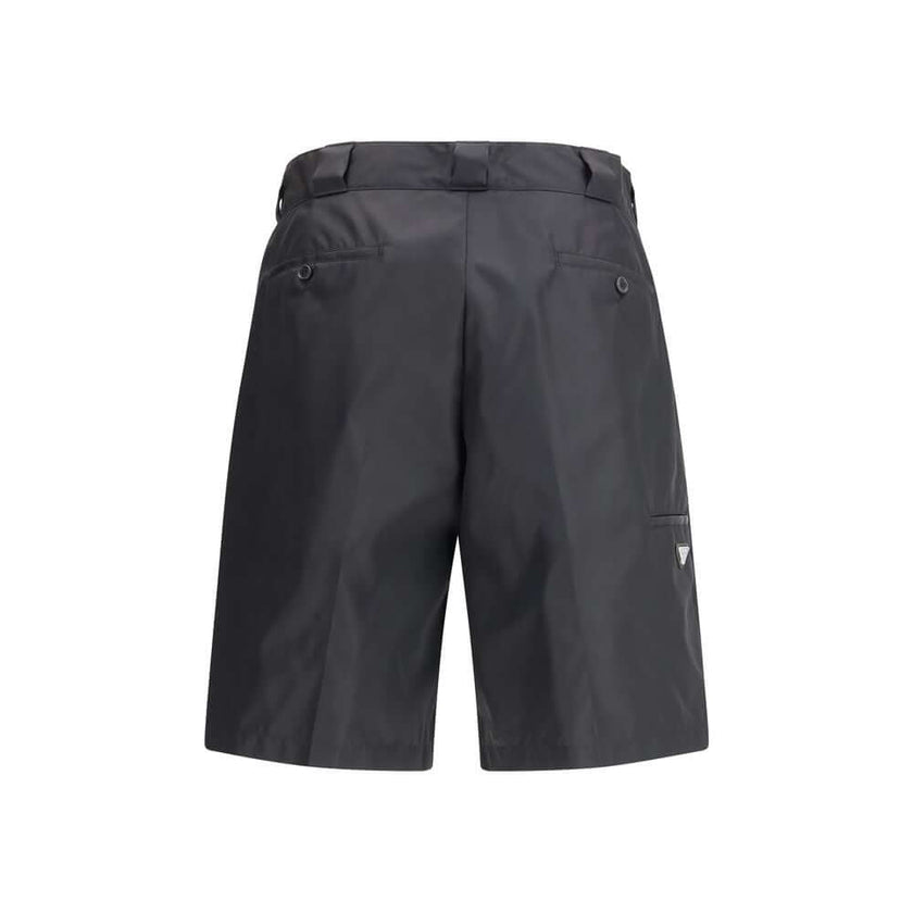 Black Recycled Polyamide Bermuda ShortsThe Re-Nylon Bermuda Shorts by Prada merge contemporary design with a sustainable ethos. Crafted from ECONYL®, a regenerated nylon yarn produced from recycled ocean plastics, fishing nets, and textile fibers, they em