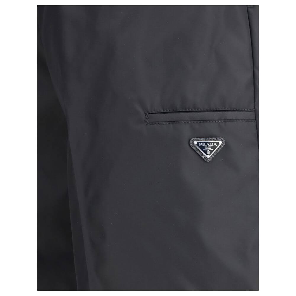 Black Recycled Polyamide Bermuda ShortsThe Re-Nylon Bermuda Shorts by Prada merge contemporary design with a sustainable ethos. Crafted from ECONYL®, a regenerated nylon yarn produced from recycled ocean plastics, fishing nets, and textile fibers, they em