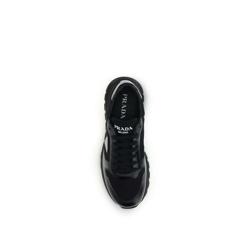 Black Recycled Polyamide Athletic SneakersPrax 01 Sneakers by Prada, made of Re-Nylon and brushed leather, combine contemporary style and innovative materials. Equipped with laces, they feature an enameled triangle logo on the upper and screen-printed Pra