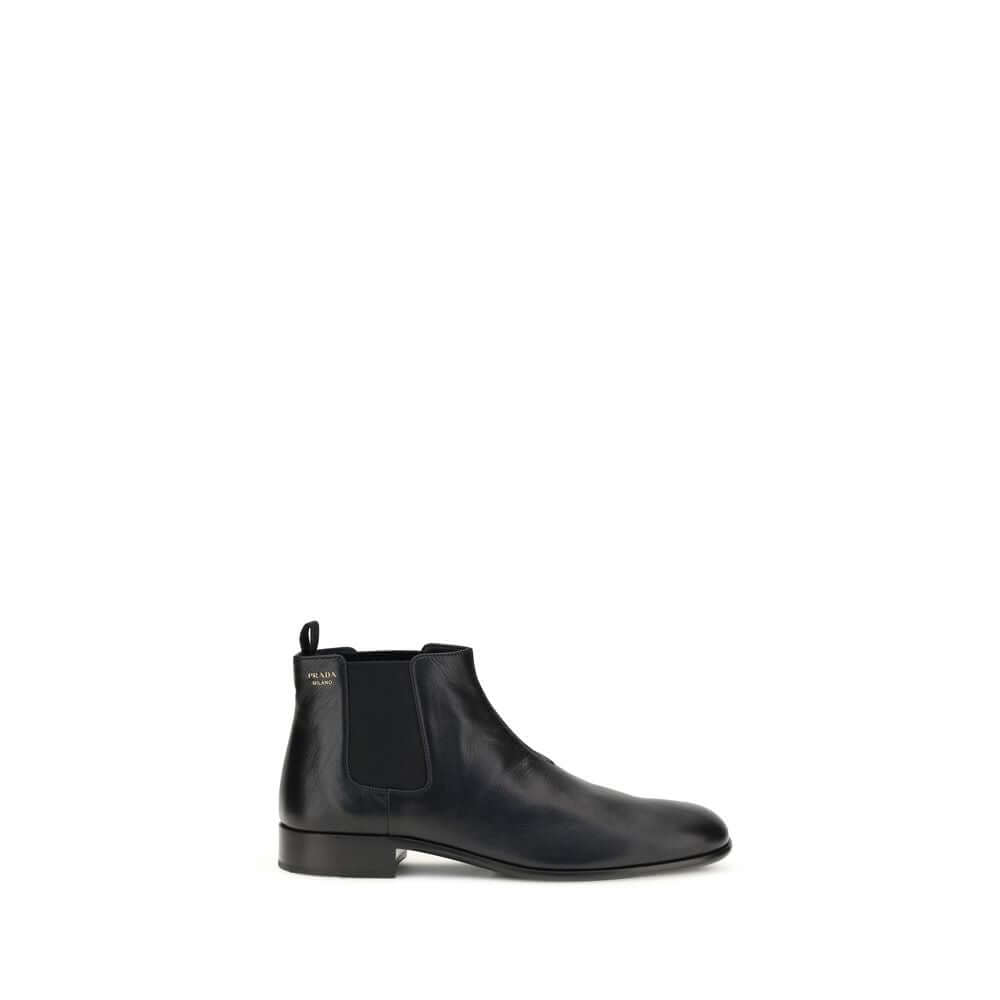 Black Leather Ankle BootsThe leather Ankle Boots by Prada reinterpret a wardrobe classic with essential lines and distinctive details. The upper is enriched with elastic side inserts and a rear pull-on for a quick and practical fit. The leather lining ens