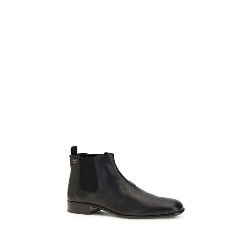 Black Leather Ankle BootsThe leather Ankle Boots by Prada reinterpret a wardrobe classic with essential lines and distinctive details. The upper is enriched with elastic side inserts and a rear pull-on for a quick and practical fit. The leather lining ens