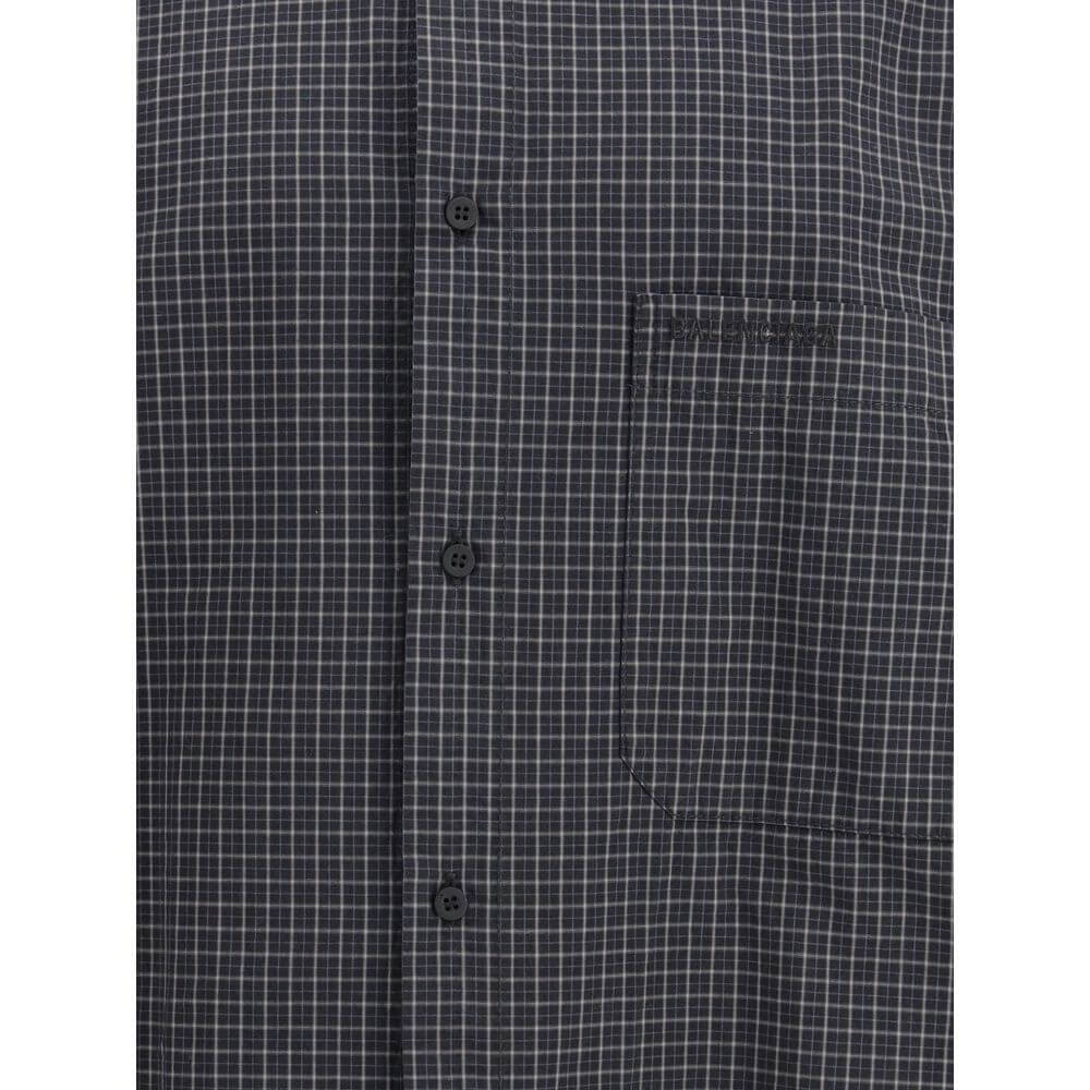 Black Wool Pattern ShirtThe oversized checked Shirt by Balenciaga is crafted from checked wool-blend flannel, reimagining a classic silhouette with a modern oversized cut. It features a button-down collar, seven front buttons engraved with Balenciaga, a c