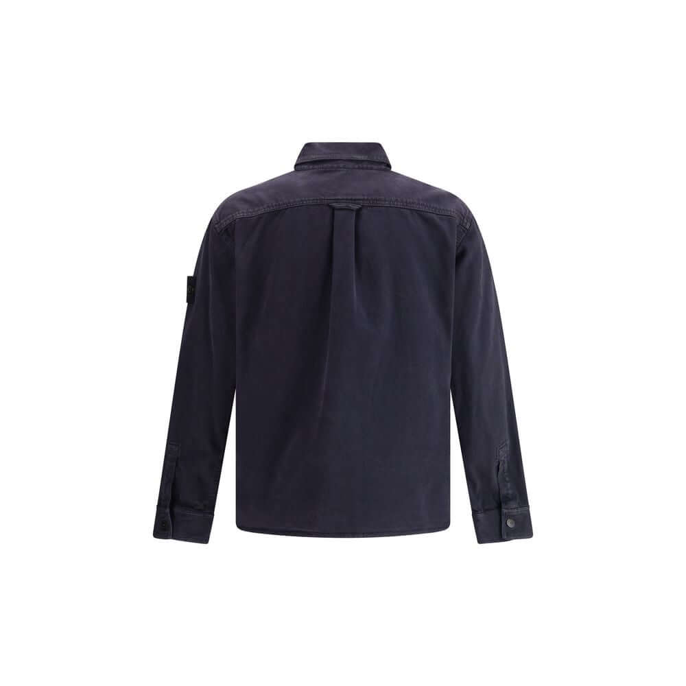 Blue Cotton Dress ShirtThe Stone Island Overshirt, crafted from 100% black cotton, is a versatile essential that blends functionality with contemporary style. Featuring a button fastening, two chest patch pockets, and the iconic logo patch on the left sle