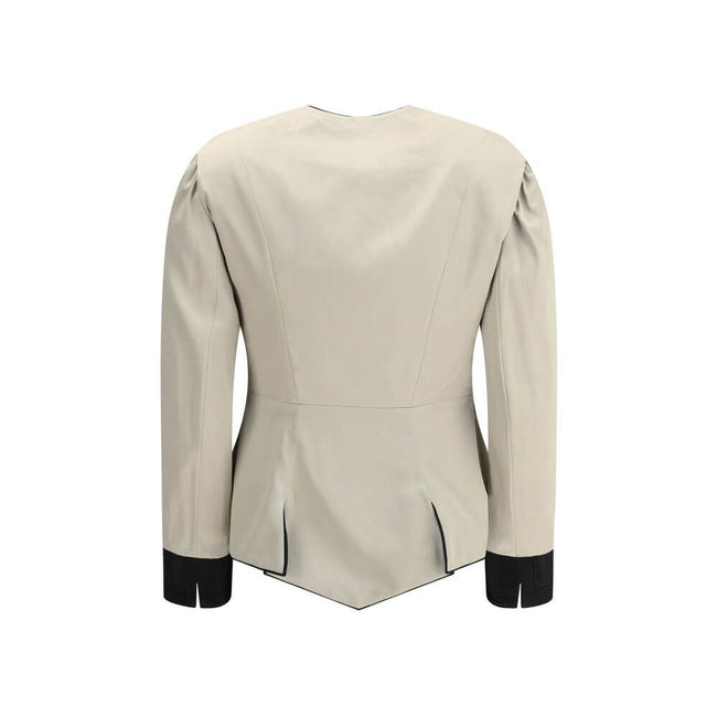 Silver Silk CoatThe Tailored Silk Jacket by Chloé reimagines classic elegance with refined details and a strong architectural touch. Its deep V-neckline is layered with a contrasting white placket, accentuated by gold-tone floral buttons for a luminous fi