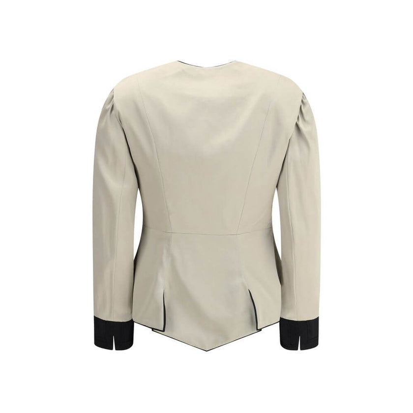 Silver Silk CoatThe Tailored Silk Jacket by Chloé reimagines classic elegance with refined details and a strong architectural touch. Its deep V-neckline is layered with a contrasting white placket, accentuated by gold-tone floral buttons for a luminous fi