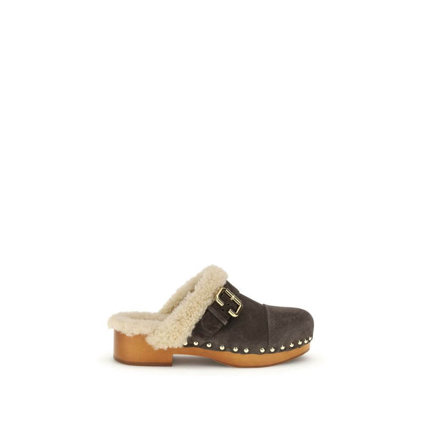 Brown Fur ClogsThe Jeannette Clogs by Chloé are crafted from suede and lined with soft shearling for warm, cozy comfort. They are embellished with gold-tone studs and buckles shaped like the brand’s initial. The wooden sole and suede upper combine traditi