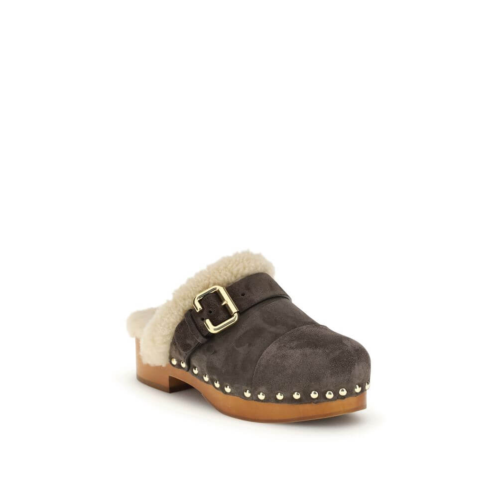 Brown Fur ClogsThe Jeannette Clogs by Chloé are crafted from suede and lined with soft shearling for warm, cozy comfort. They are embellished with gold-tone studs and buckles shaped like the brand’s initial. The wooden sole and suede upper combine traditi