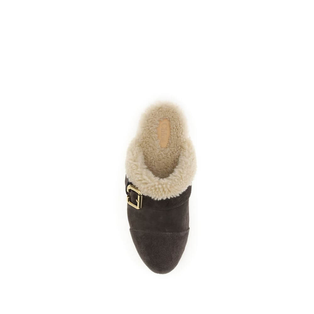 Brown Fur ClogsThe Jeannette Clogs by Chloé are crafted from suede and lined with soft shearling for warm, cozy comfort. They are embellished with gold-tone studs and buckles shaped like the brand’s initial. The wooden sole and suede upper combine traditi