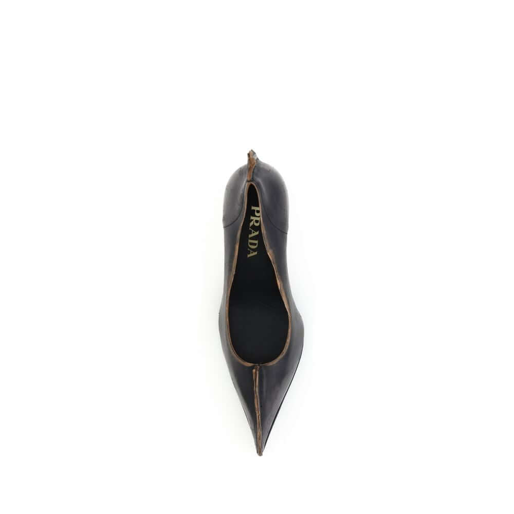 Black Leather High Heel PumpsPrada’s leather Pumps are an elegant model with retro appeal, made of leather with a vintage effect. The pointed silhouette is enhanced by the laminated printed logo on the instep, a distinctive and sophisticated detail. The d