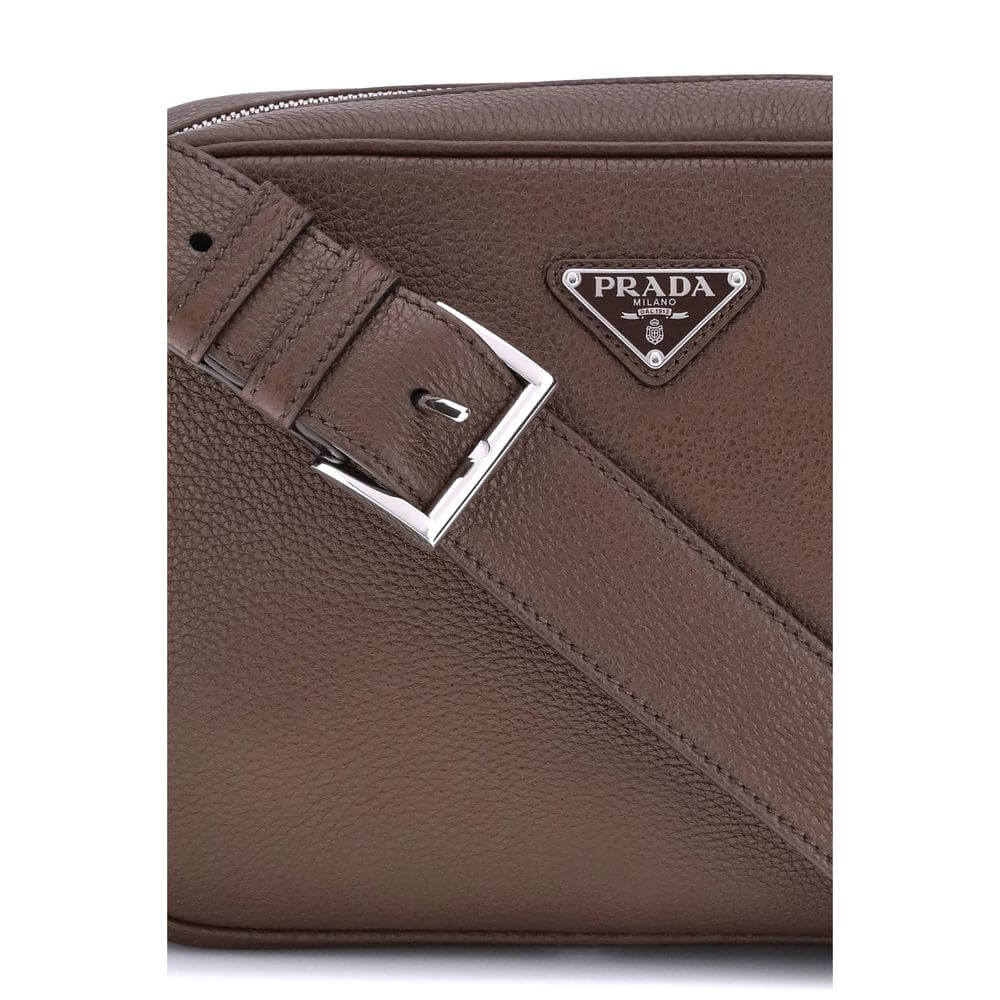 Brown Calf Leather Bos Taurus Shoulder BagPrada’s Logo Shoulder Bag is an elegant and functional accessory made of fine calfskin leather. Featuring a zippered closure and an adjustable buckled shoulder strap, it has metal hardware that enhances its charac