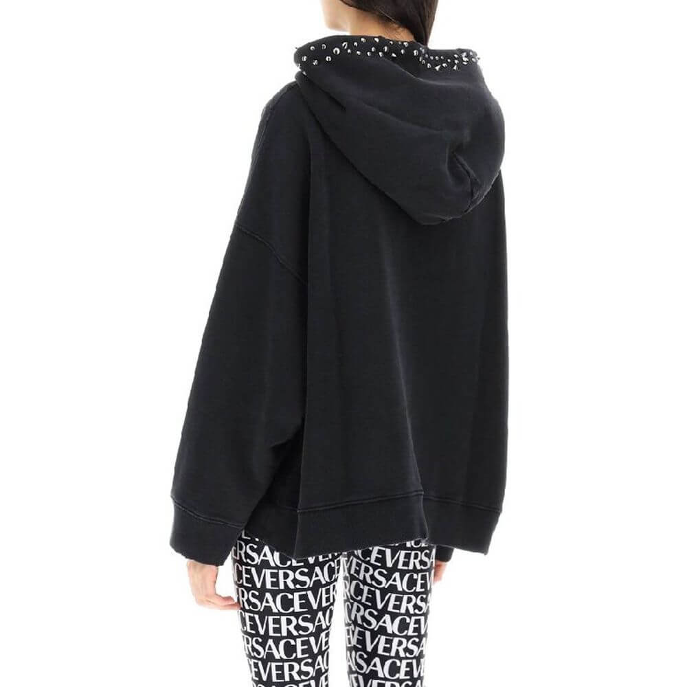 Black Cotton SweatshirtDescription: – Composition: 100% cotton – Long sleeves – Hood – Metal applications – Kangaroo pocket – Ribbed trims – Front logo detail – Machine wash (delicate) – Made in Portugal –Black Cotton Sweatshirt${tagsVersaceAulae Black Co