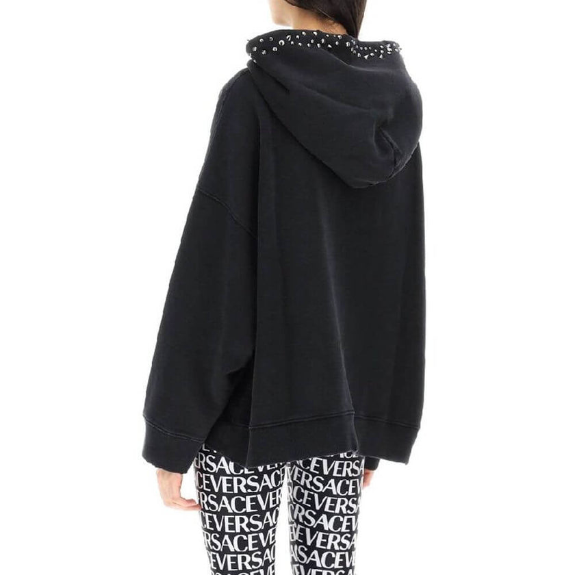 Black Cotton SweatshirtDescription: – Composition: 100% cotton – Long sleeves – Hood – Metal applications – Kangaroo pocket – Ribbed trims – Front logo detail – Machine wash (delicate) – Made in Portugal –Black Cotton Sweatshirt${tagsVersaceAulae Black Co