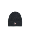Black Merino Wool BeanieBeanie Hat by Moncler Grenoble combines functionality and style in an essential cold-weather accessory. Made with ribbed fabrication, it offers a snug and comfortable fit. The Moncler Grenoble logo sewn on the front adds a distinct