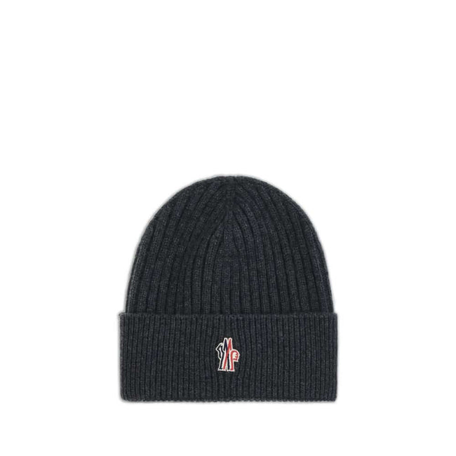 Black Merino Wool BeanieBeanie Hat by Moncler Grenoble combines functionality and style in an essential cold-weather accessory. Made with ribbed fabrication, it offers a snug and comfortable fit. The Moncler Grenoble logo sewn on the front adds a distinct