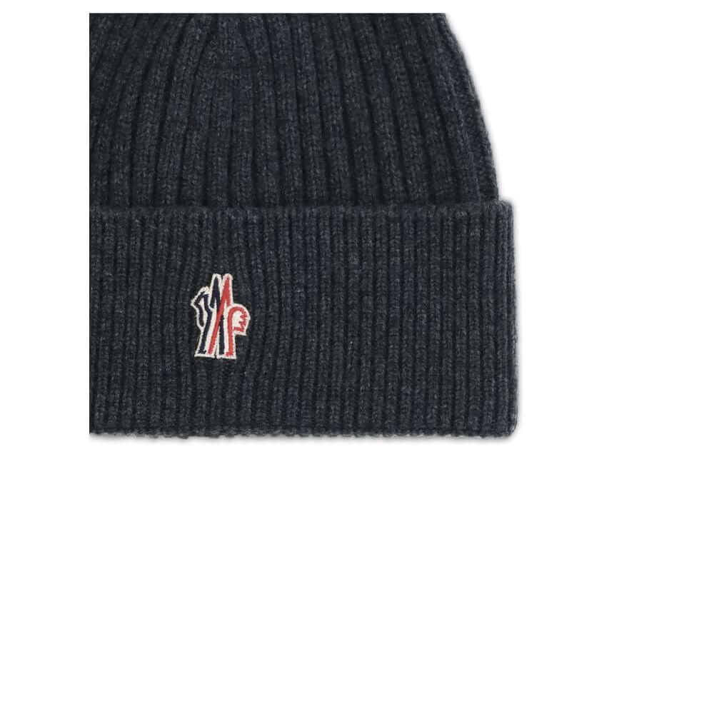 Black Merino Wool BeanieBeanie Hat by Moncler Grenoble combines functionality and style in an essential cold-weather accessory. Made with ribbed fabrication, it offers a snug and comfortable fit. The Moncler Grenoble logo sewn on the front adds a distinct