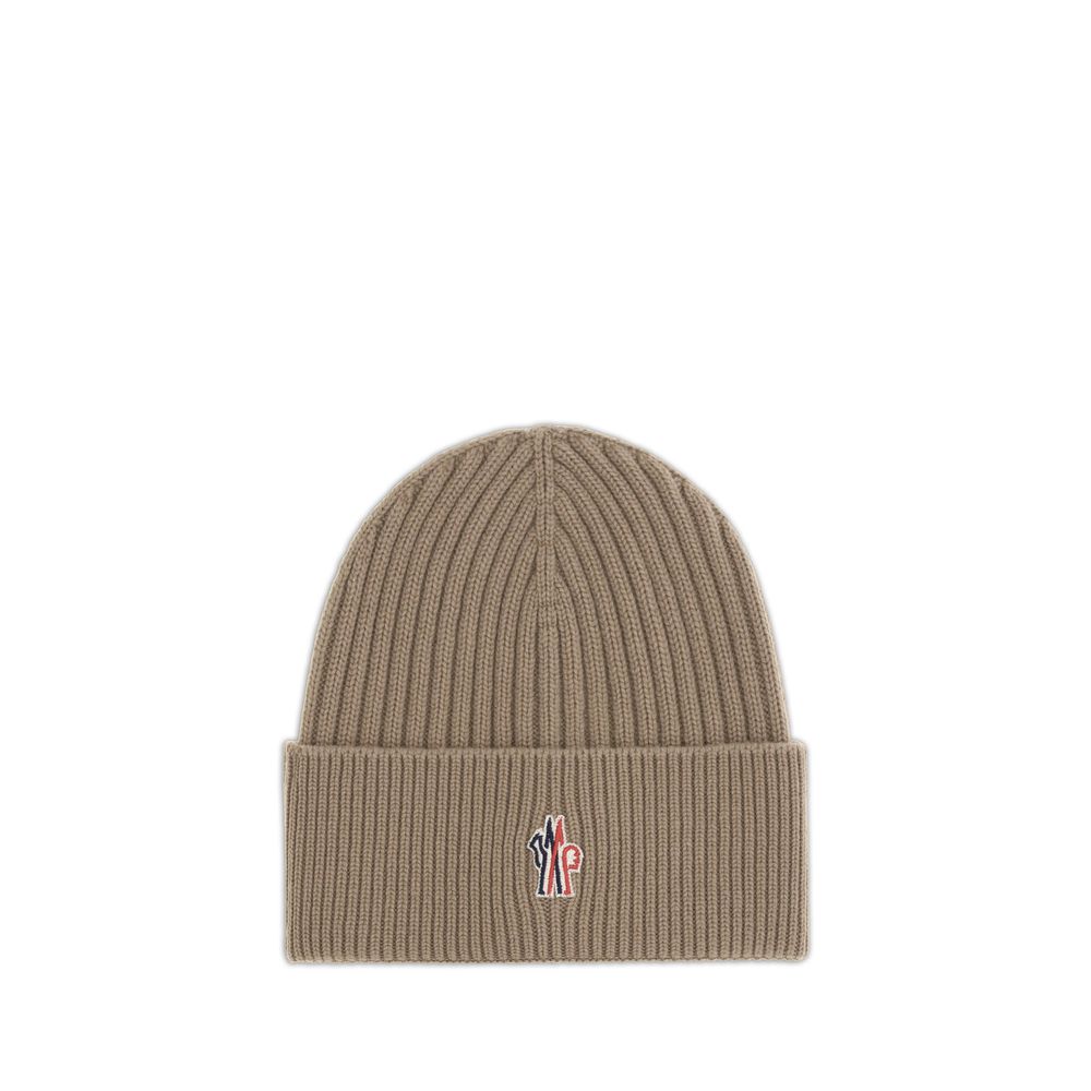 Beige Merino Wool BeanieBeanie Hat by Moncler Grenoble combines functionality and style in an essential cold-weather accessory. Made with ribbed fabrication, it offers a snug and comfortable fit. The Moncler Grenoble logo sewn on the front adds a distinct
