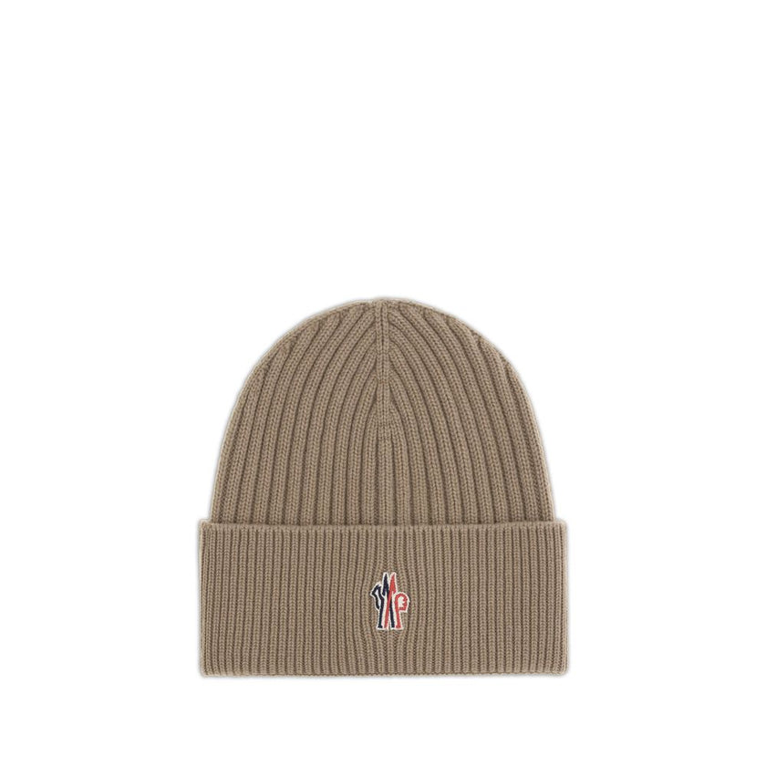 Beige Merino Wool BeanieBeanie Hat by Moncler Grenoble combines functionality and style in an essential cold-weather accessory. Made with ribbed fabrication, it offers a snug and comfortable fit. The Moncler Grenoble logo sewn on the front adds a distinct