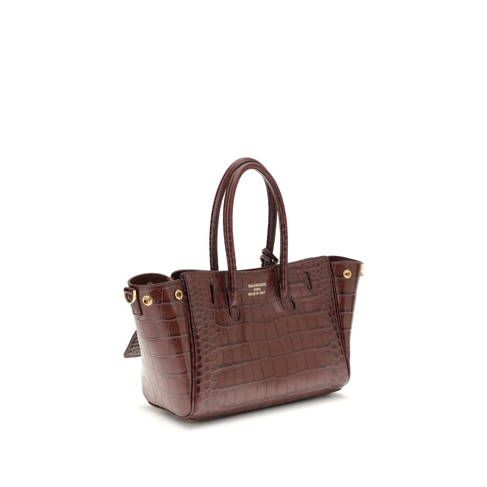Bordeaux Calf Leather Bos Taurus Shoulder BagBel Air mini Shoulder Bag by Balenciaga, is made of calfskin leather with crocodile processing, combining sophistication and iconic design. The carry-all model features two handles joined by a clip and an adjus