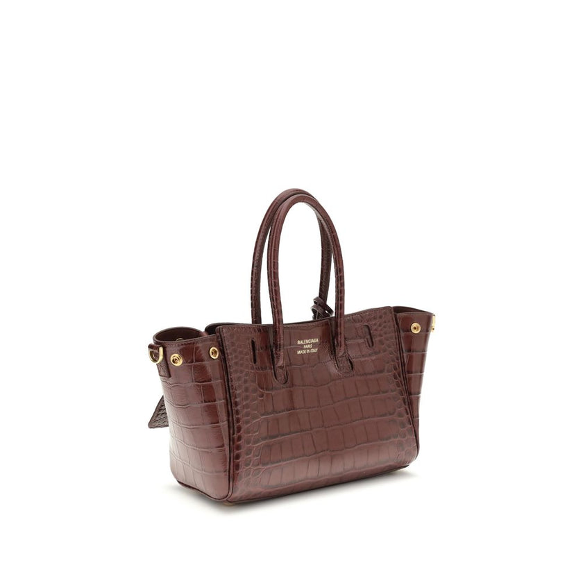Bordeaux Calf Leather Bos Taurus Shoulder BagBel Air mini Shoulder Bag by Balenciaga, is made of calfskin leather with crocodile processing, combining sophistication and iconic design. The carry-all model features two handles joined by a clip and an adjus