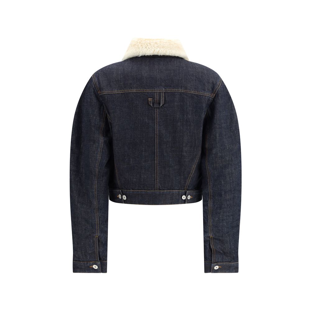 Blue Cotton SweatshirtThe De-Nîmes Ovalo Denim Bomber by Jacquemus reimagines the classic aviator silhouette with a contemporary and artisanal touch. Crafted from rinsed raw indigo denim, it features contrasting stitching and a pointed faux-shearling coll