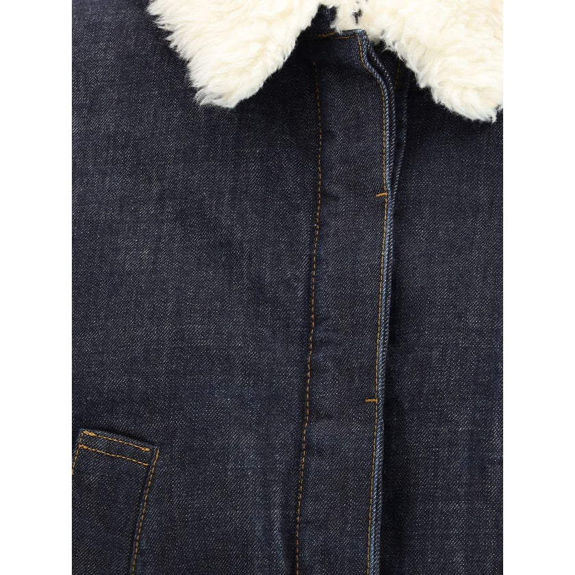 Blue Cotton SweatshirtThe De-Nîmes Ovalo Denim Bomber by Jacquemus reimagines the classic aviator silhouette with a contemporary and artisanal touch. Crafted from rinsed raw indigo denim, it features contrasting stitching and a pointed faux-shearling coll