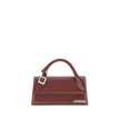 Bordeaux Calf Leather Bos Taurus HandbagThe Chiquito Handbag with Buckle from Jacquemus is a long, structured design made of smooth leather. Featuring a reinforced handle with metal buckle, it has a flap with magnetic closure and an adjustable, removable