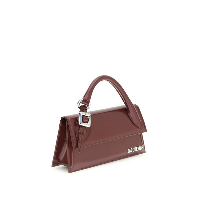 Bordeaux Calf Leather Bos Taurus HandbagThe Chiquito Handbag with Buckle from Jacquemus is a long, structured design made of smooth leather. Featuring a reinforced handle with metal buckle, it has a flap with magnetic closure and an adjustable, removable