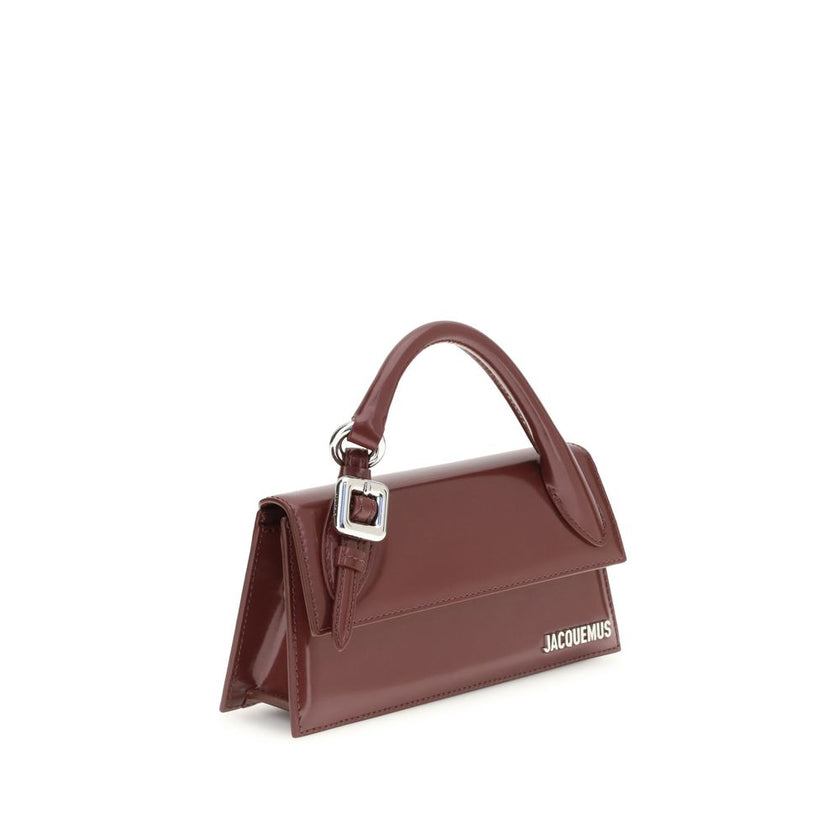 Bordeaux Calf Leather Bos Taurus HandbagThe Chiquito Handbag with Buckle from Jacquemus is a long, structured design made of smooth leather. Featuring a reinforced handle with metal buckle, it has a flap with magnetic closure and an adjustable, removable
