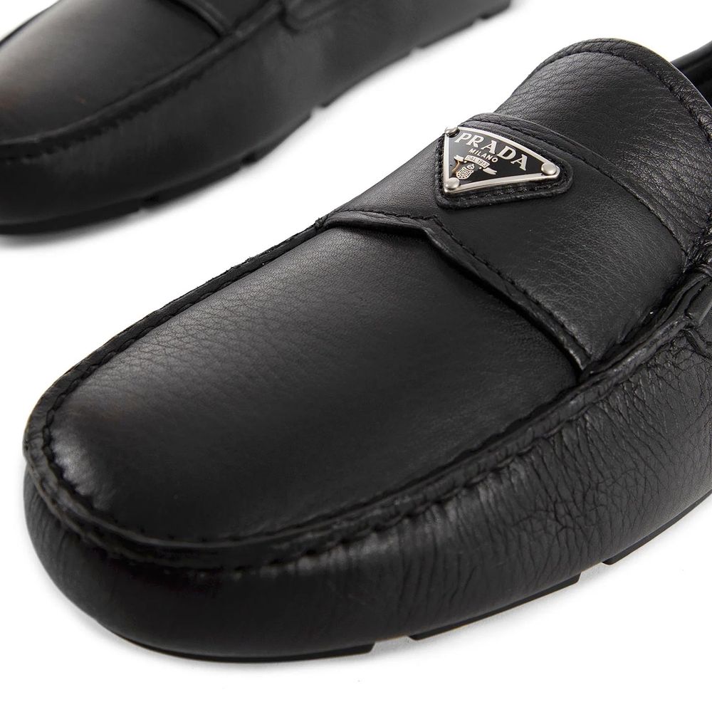Black Calfskin Slip-On LoafersDescription: – Composition: 100% calf leather – Inner: Leather – Insole: Leather – Sole: Rubber – Round toe – Textured leather – Branded insole – Non-slip knurled sole – Iconic triangular signature brand plaque – Made in Ital
