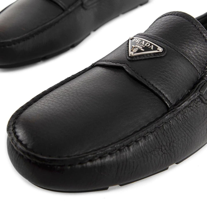 Black Calfskin Slip-On LoafersDescription: – Composition: 100% calf leather – Inner: Leather – Insole: Leather – Sole: Rubber – Round toe – Textured leather – Branded insole – Non-slip knurled sole – Iconic triangular signature brand plaque – Made in Ital