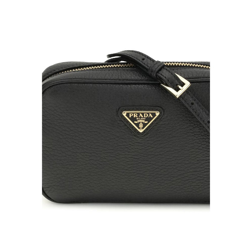 Black Calf Leather Bos Taurus Shoulder BagMini Shoulder Bag by Prada is a compact and essential accessory perfect for everyday use. Featuring a zippered top closure and an adjustable, removable shoulder strap, it combines practicality and style. The inter