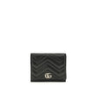 Black Lamb Ovis Aries Aries WalletThe GG Marmont Wallet by Gucci is an elegant and functional accessory made of matelassé nappa leather with a pinkish beige chevron pattern. The design is embellished with light gold-tone hardware and the famous double G o