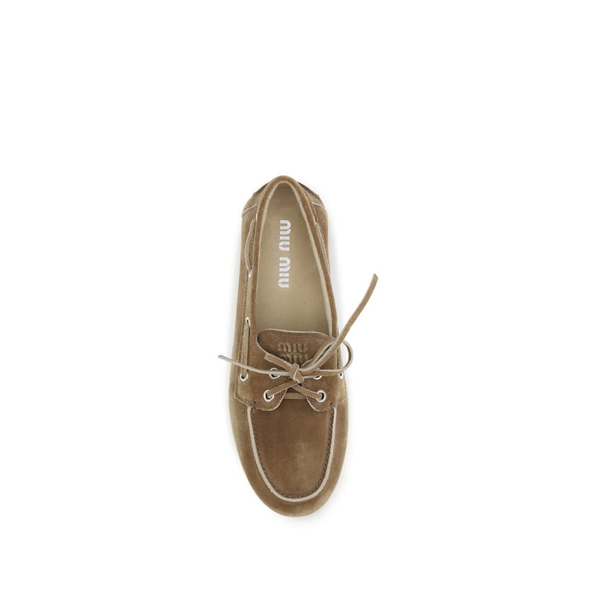Beige Calf Leather Bos Taurus Slip-On LoafersThe delavé suede unlined Loafers by Miu Miu reinterpret the classic nautical style with a modern and creative approach, allowing for novel and surprising pairings. The model features a bow tray and embossed log