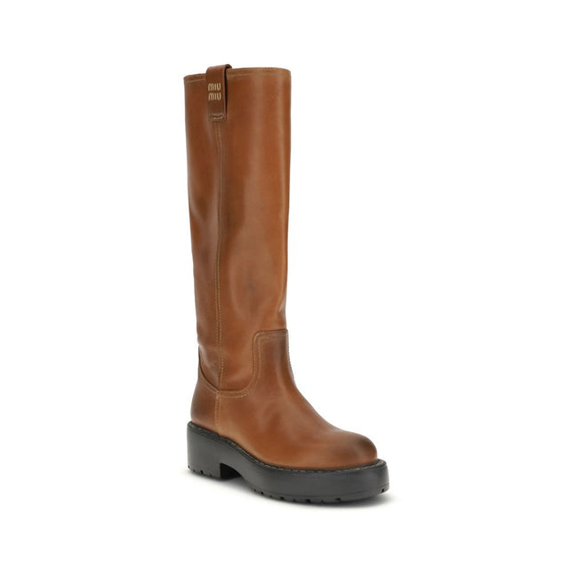 Brown Calf Leather Bos Taurus BootsThe Leather Boots by Miu Miu are crafted from smooth, premium leather and stand out for their sleek yet refined design. They feature a logo tab on the front and a double pull tab for easier wear, adding a signature touch