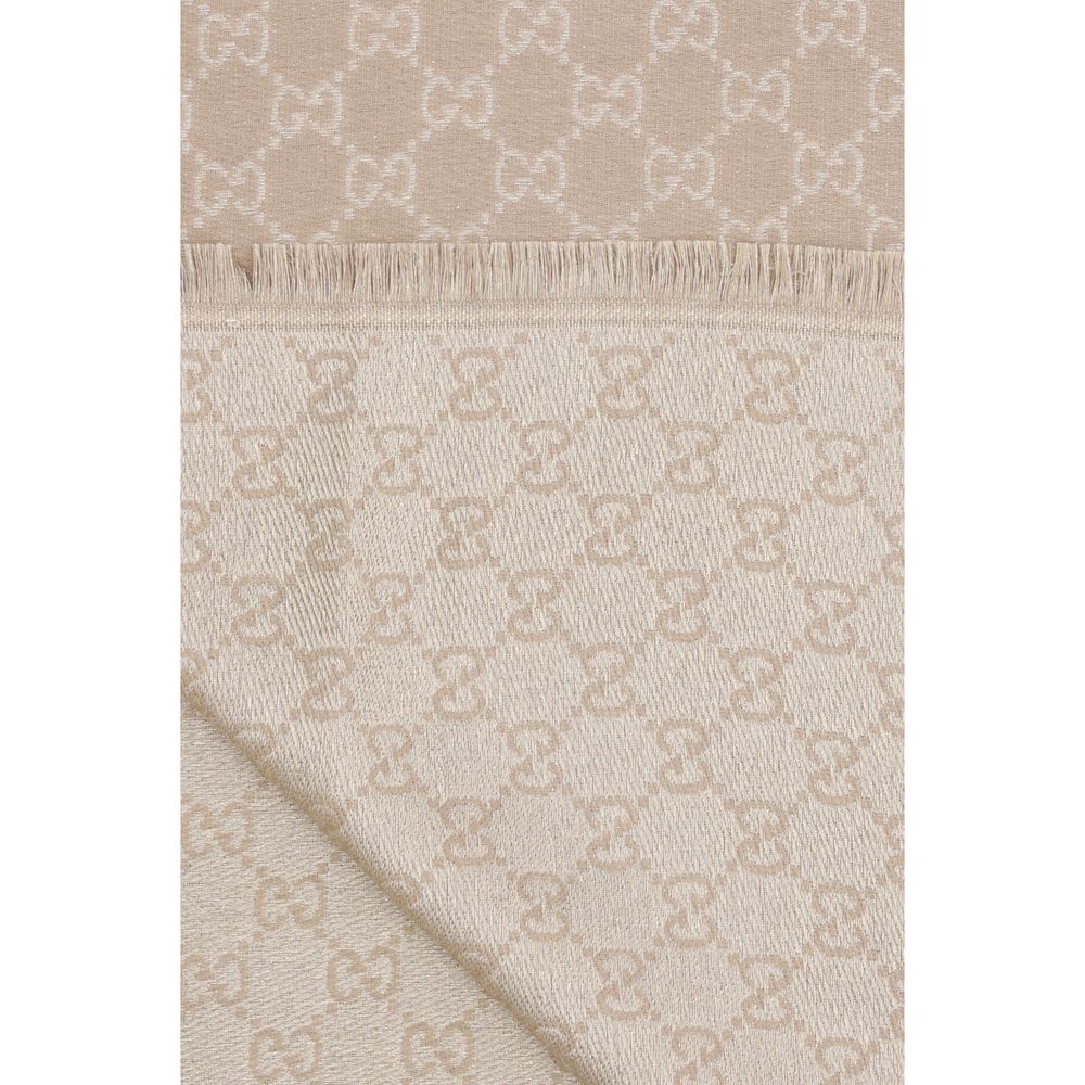 Beige Wool ScarfThe GG Supreme print wool Scarf by Gucci combines warmth and style in an iconic Maison accessory. Crafted from a wool blend with lurex threads, it features a GG print across the entire surface, while frayed hems complete the design with a