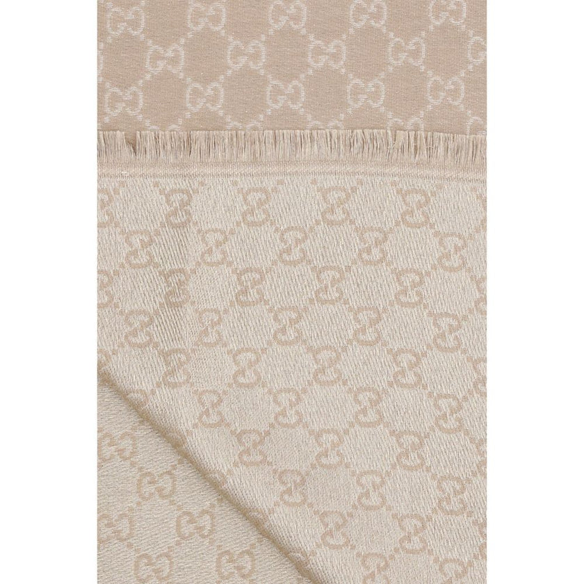 Beige Wool ScarfThe GG Supreme print wool Scarf by Gucci combines warmth and style in an iconic Maison accessory. Crafted from a wool blend with lurex threads, it features a GG print across the entire surface, while frayed hems complete the design with a