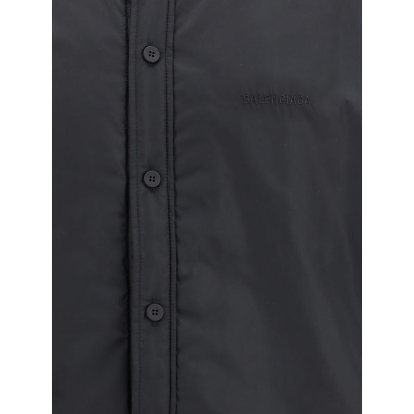 Black Polyester ClothingThe padded Jacket by Balenciaga is crafted from high-quality polyester, designed to provide warmth and comfort while maintaining a sleek aesthetic. It features a pointed collar, front button closure, and buttoned cuffs. The tonal e